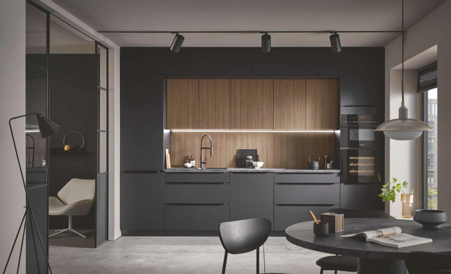 Moderne rechte keuken met zwarte fronten, houten nis en luxe inbouwapparatuur