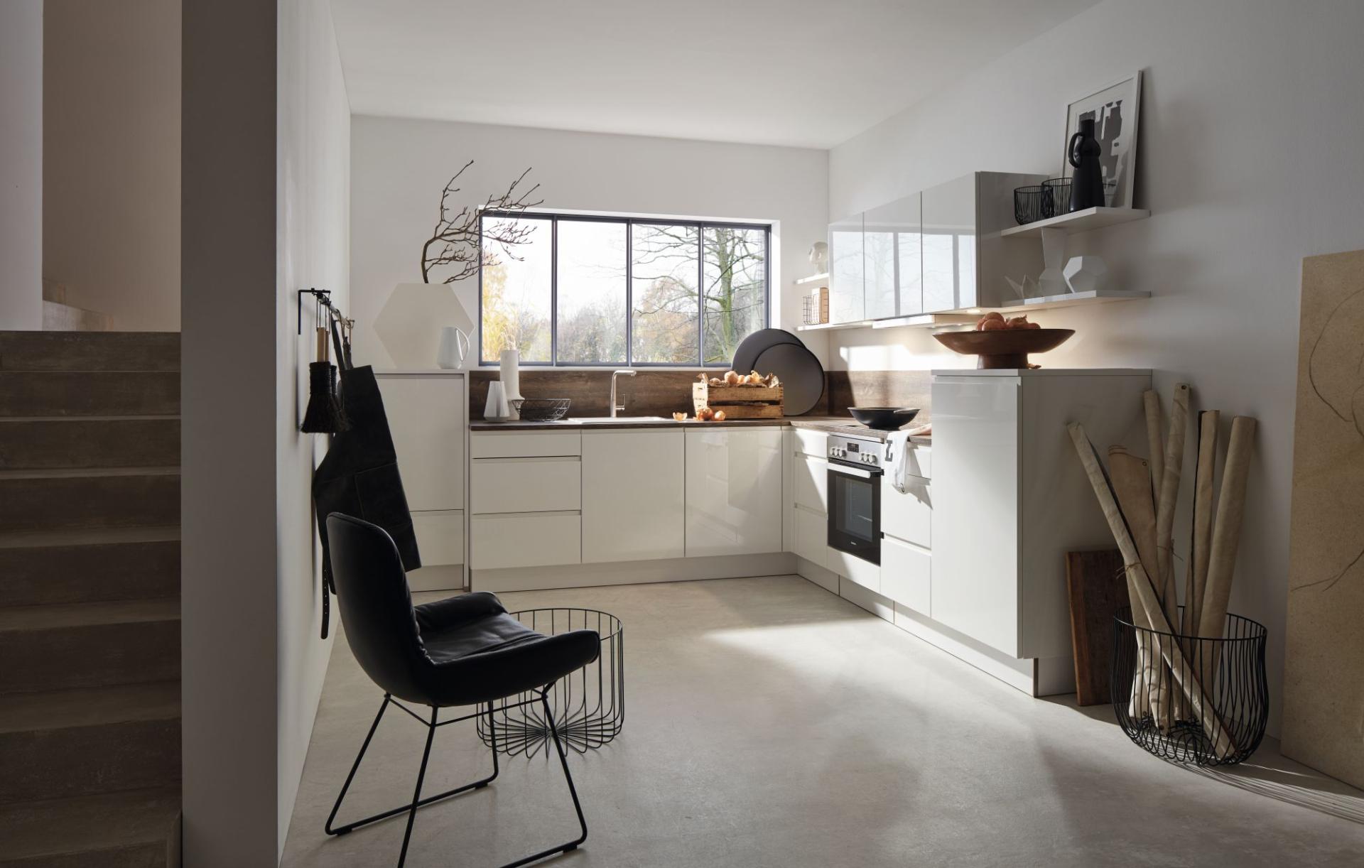 Moderne hoekkeuken met greeploze witte fronten, houtlook achterwand en luxe afwerking