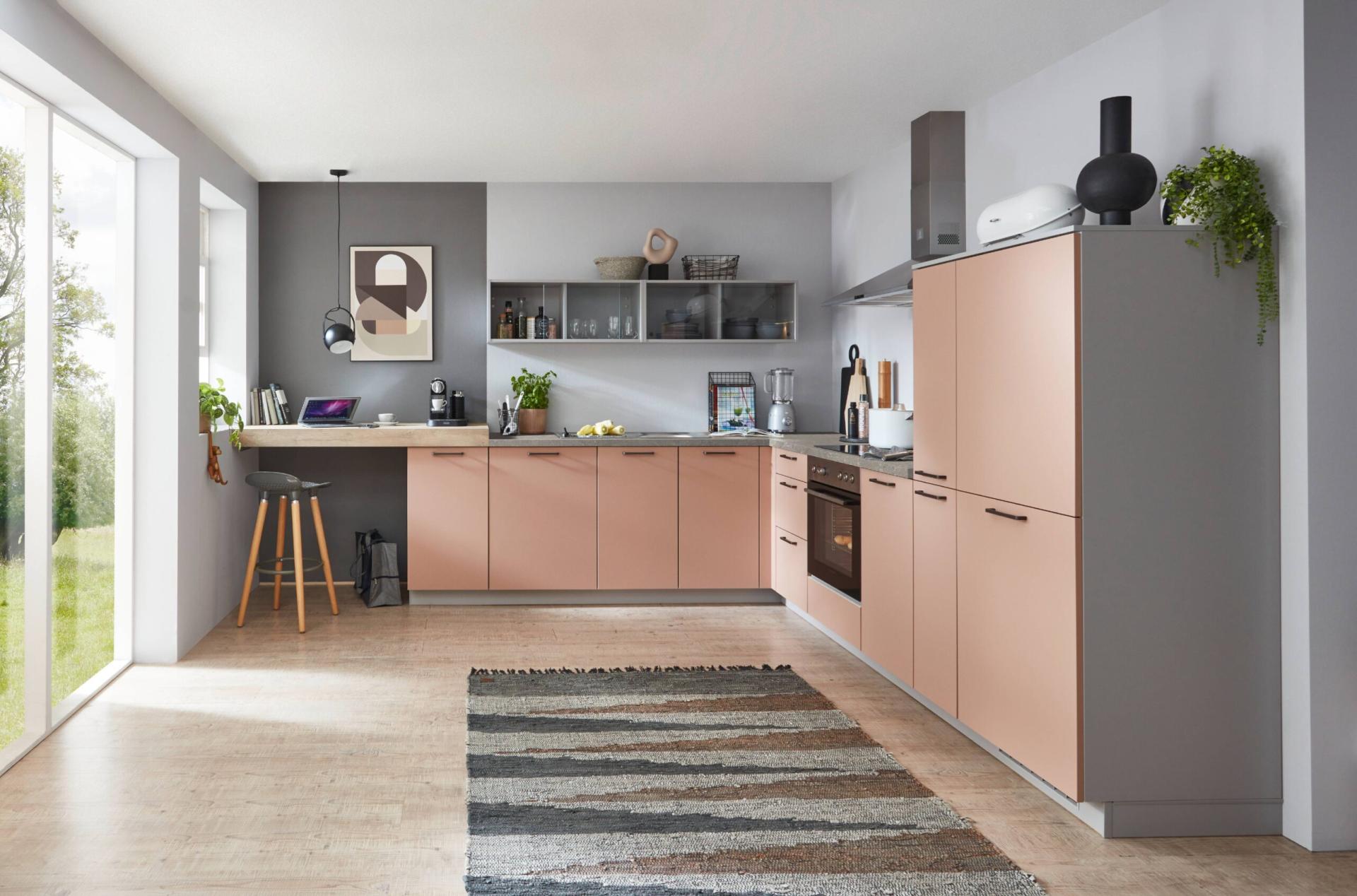 Moderne roze keuken met matte roze fronten, grijze kasten en praktische hoekopstelling