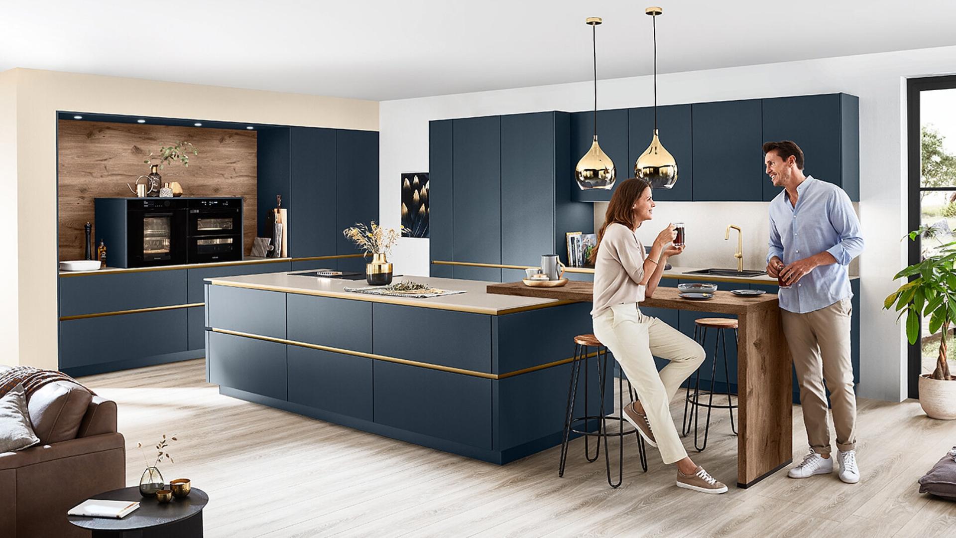 Moderne blauwe keuken met kookeiland, houten bar en gouden accenten