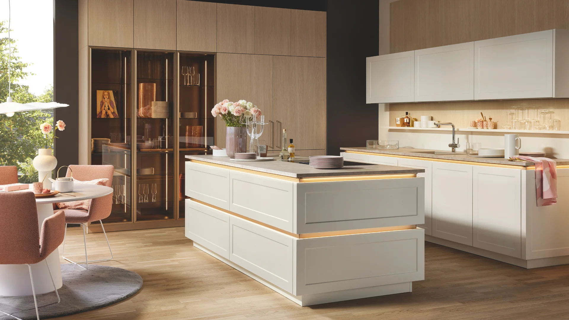 Landelijke eillandkeuken met moderne kaderfronten in magnolia gecombineerd met een moderne houten kastenwand