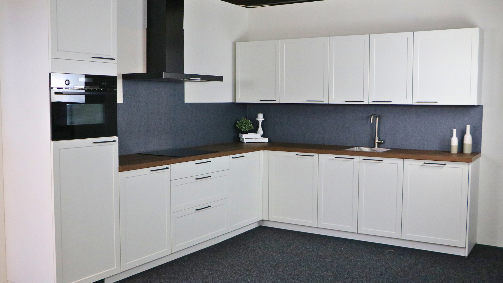 Witte landelijke kaderhoekkeuken met houtlook werkblad in de showrooms van Keukenwarenhuis.nl in Dordrecht en Ter Aar