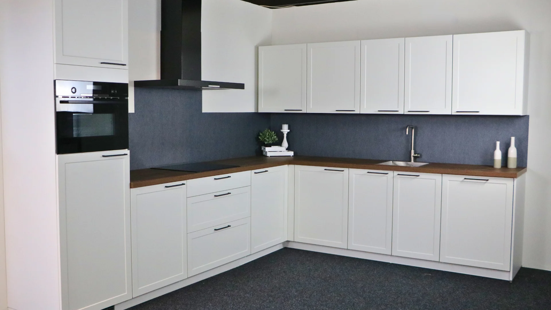 Witte landelijke kaderhoekkeuken met houtlook werkblad in de showrooms van Keukenwarenhuis.nl in Dordrecht en Ter Aar