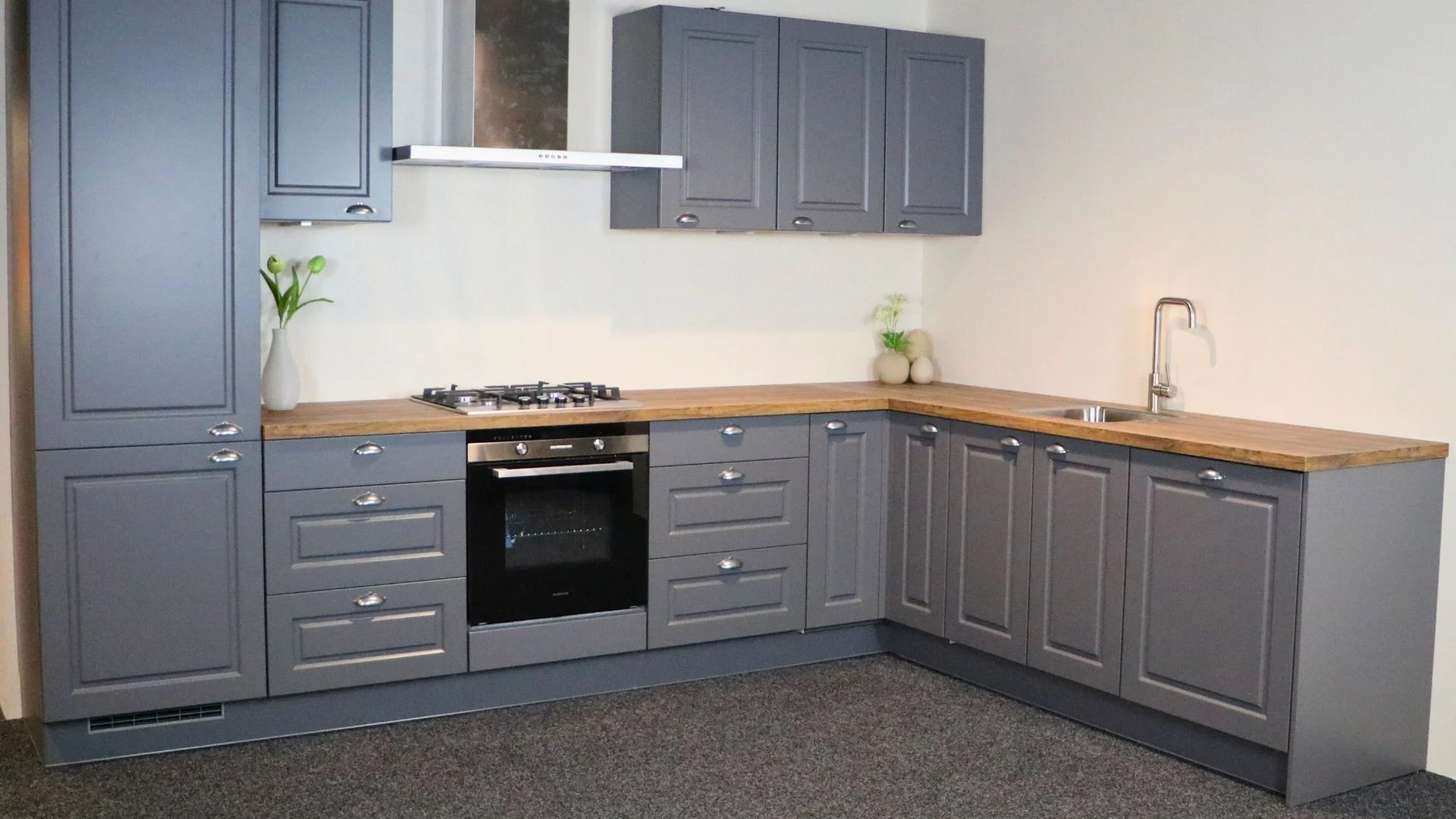 Landelijke showroom hoekkeuken met houtlook werkblad in Ter Aar