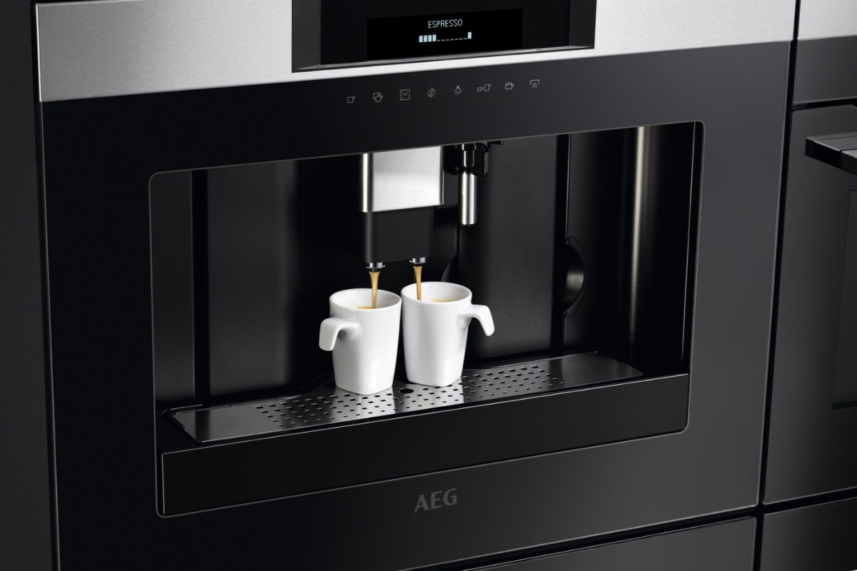 Koffiemachine met twee kopjes koffie eronder